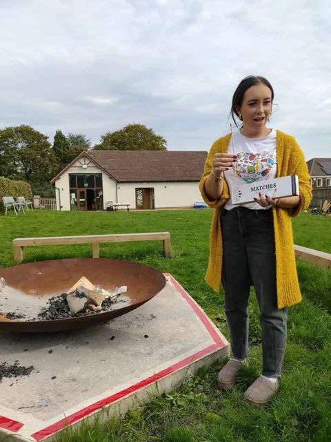 Young girl holding a certificate at the forest school outdoor learning space
